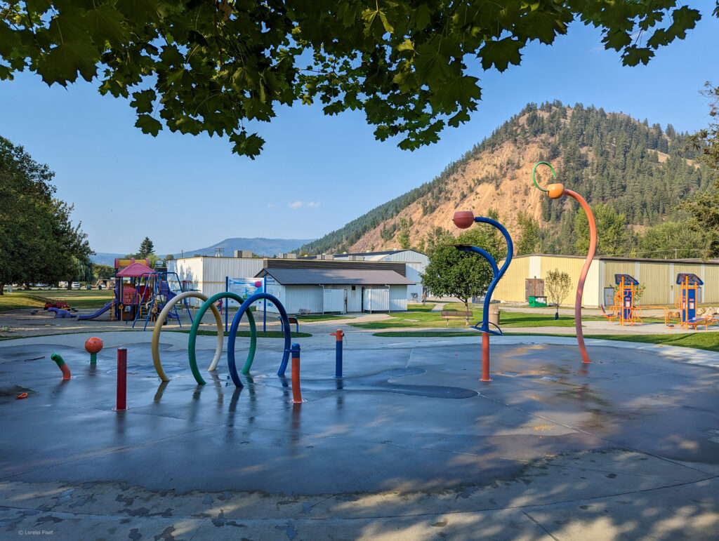 Spray park with curling rink behind in park